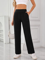 Person wearing black wide-leg pants with a white background