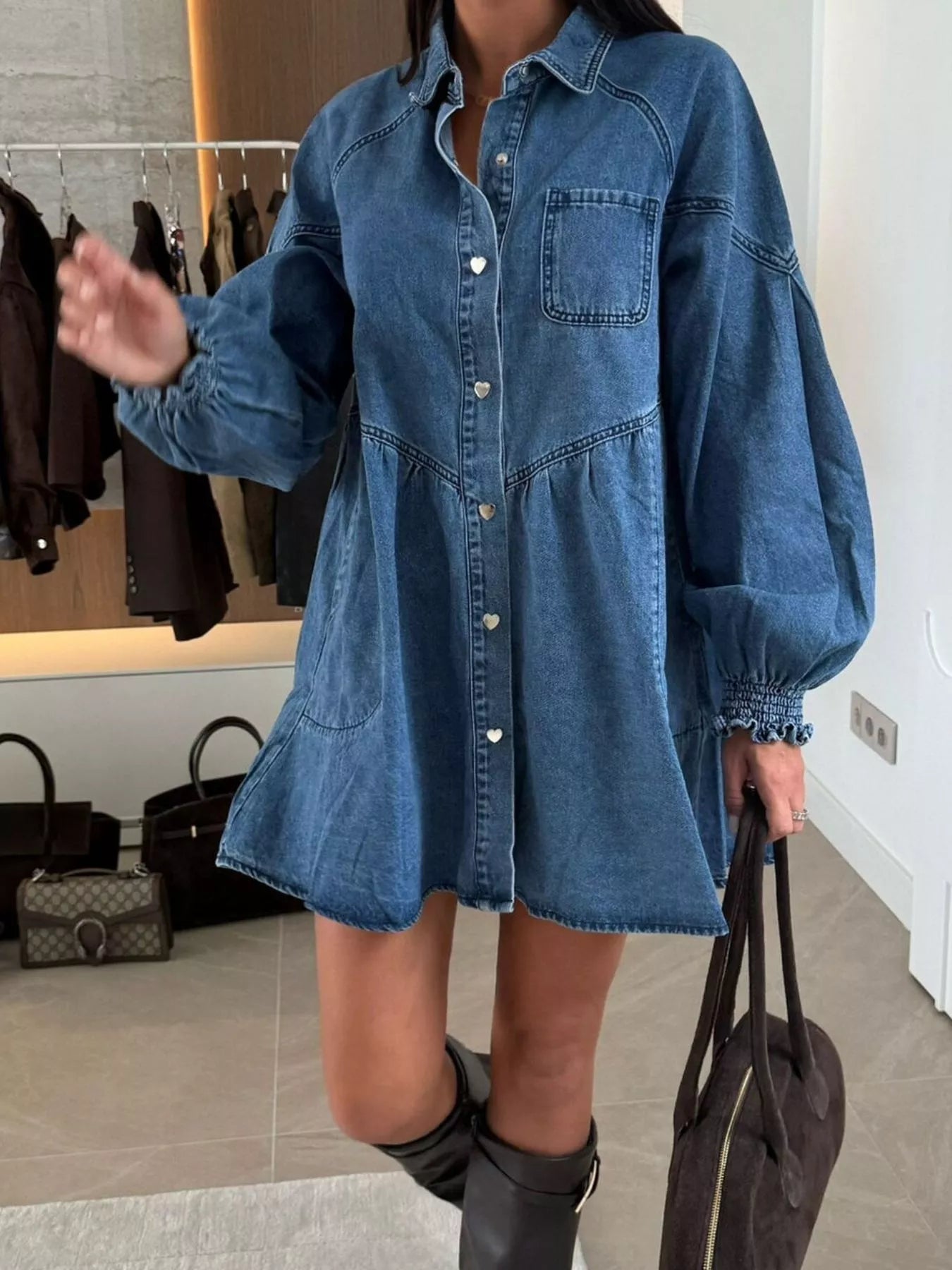 Person wearing a blue denim dress in a clothing store.