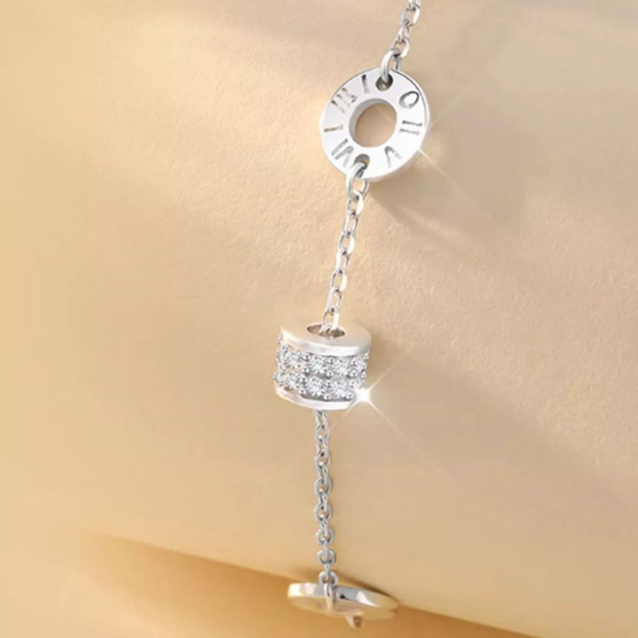 Silver charm with chain on a beige background