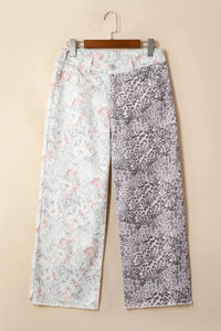 Two pairs of pants with different patterns hanging on a beige wall.