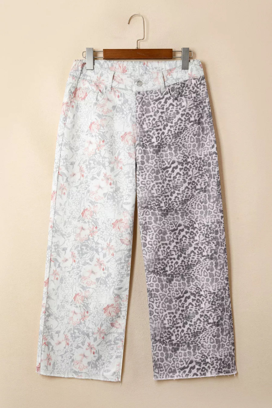 Two pairs of pants with different patterns hanging on a beige wall.