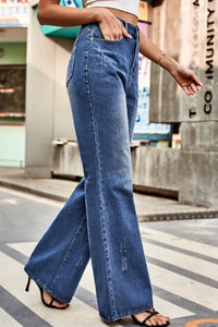 Person wearing blue jeans walking on a city street.