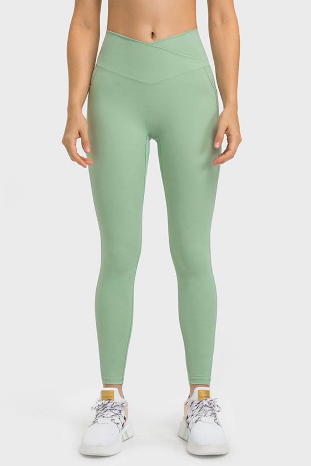 Person wearing green leggings on a white background