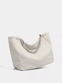 Beige handbag with a chain detail on a white background