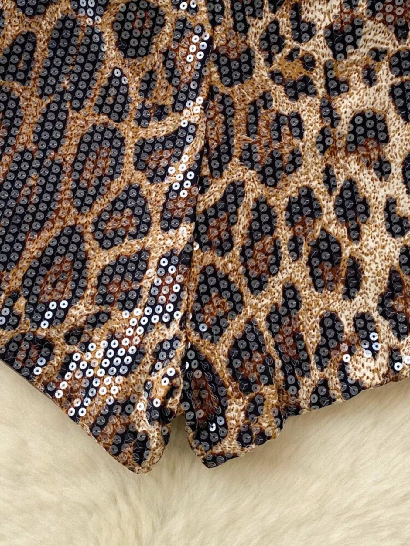 Leopard print fabric with sequins on a beige background