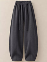 Dark gray wide-leg lounge pants with an elastic drawstring waist and tapered legs, shown against a solid beige background.