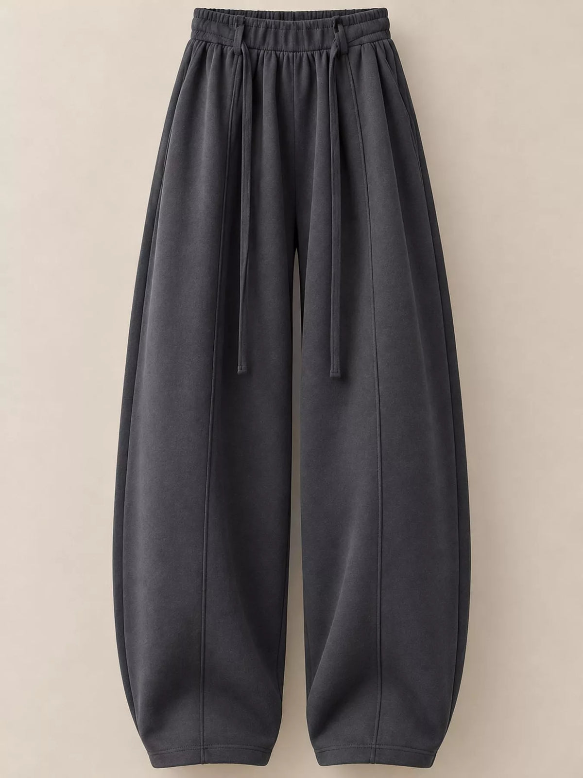 Dark gray wide-leg lounge pants with an elastic drawstring waist and tapered legs, shown against a solid beige background.