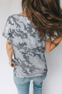 Person wearing a camouflage t-shirt and jeans on a plain background
