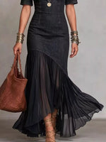 Person wearing a black dress with a brown bag on a neutral background