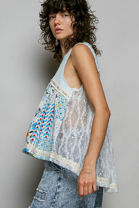 Woman wearing a sleeveless, patterned top with a gray background
