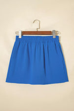 Blue skirt on a hanger against a beige background
