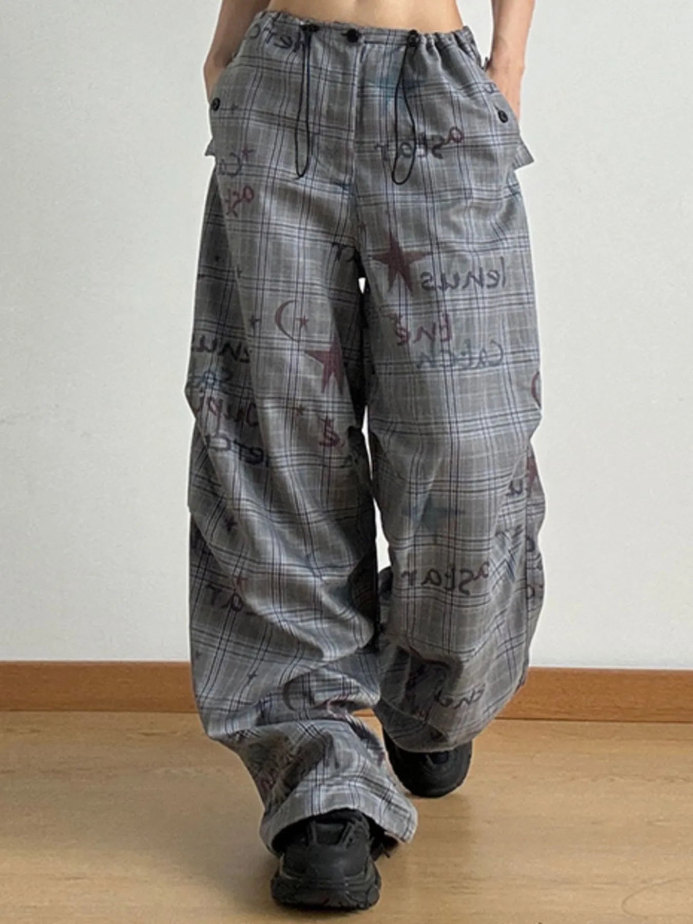 Plaid pants with text pattern worn by a person on a plain background