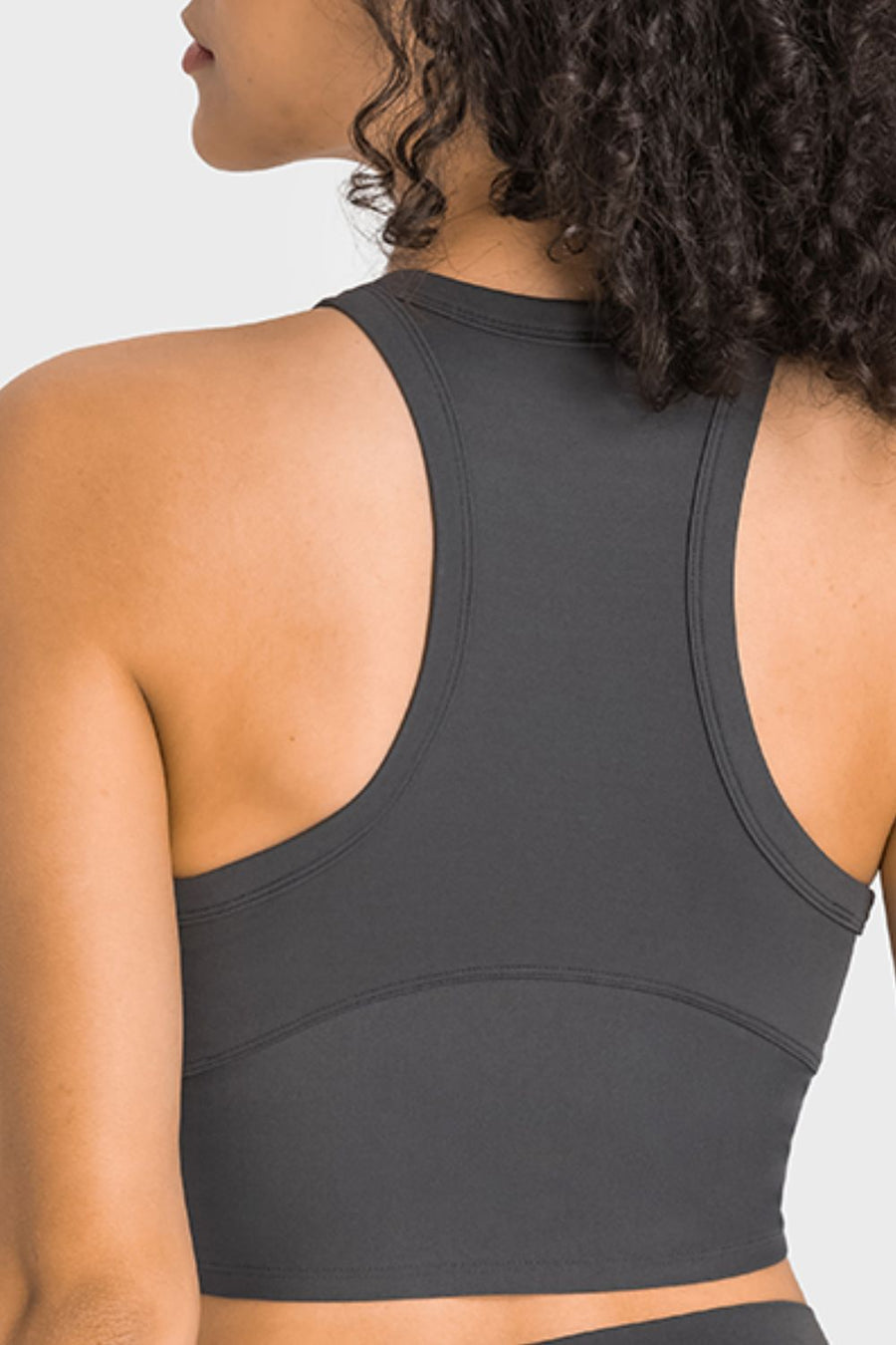 Person wearing a gray sports bra on a white background