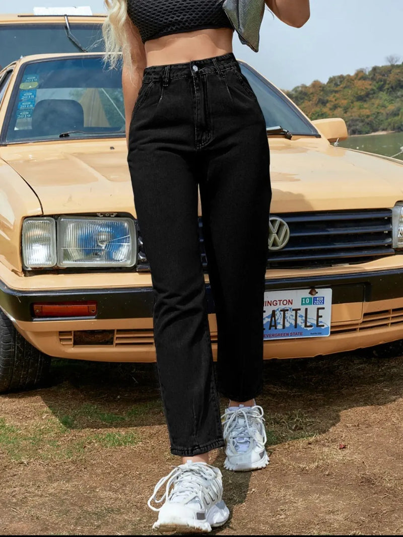 Person wearing black pants and white sneakers standing in front of a tan Volkswagen car with 'ATTLE' license plate.