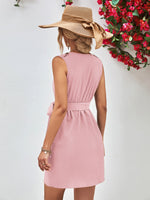 Woman wearing a pink dress and straw hat with a white background and red flowers.