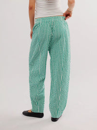 Green checkered pants worn by a person on a white background