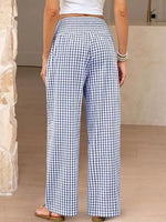 Person wearing blue and white checkered pants in a neutral setting