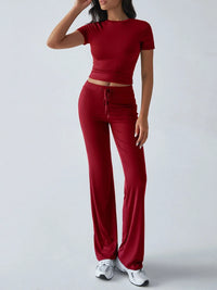 Person wearing a red outfit with a matching top and pants on a white background
