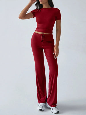 Person wearing a red outfit with a matching top and pants on a white background