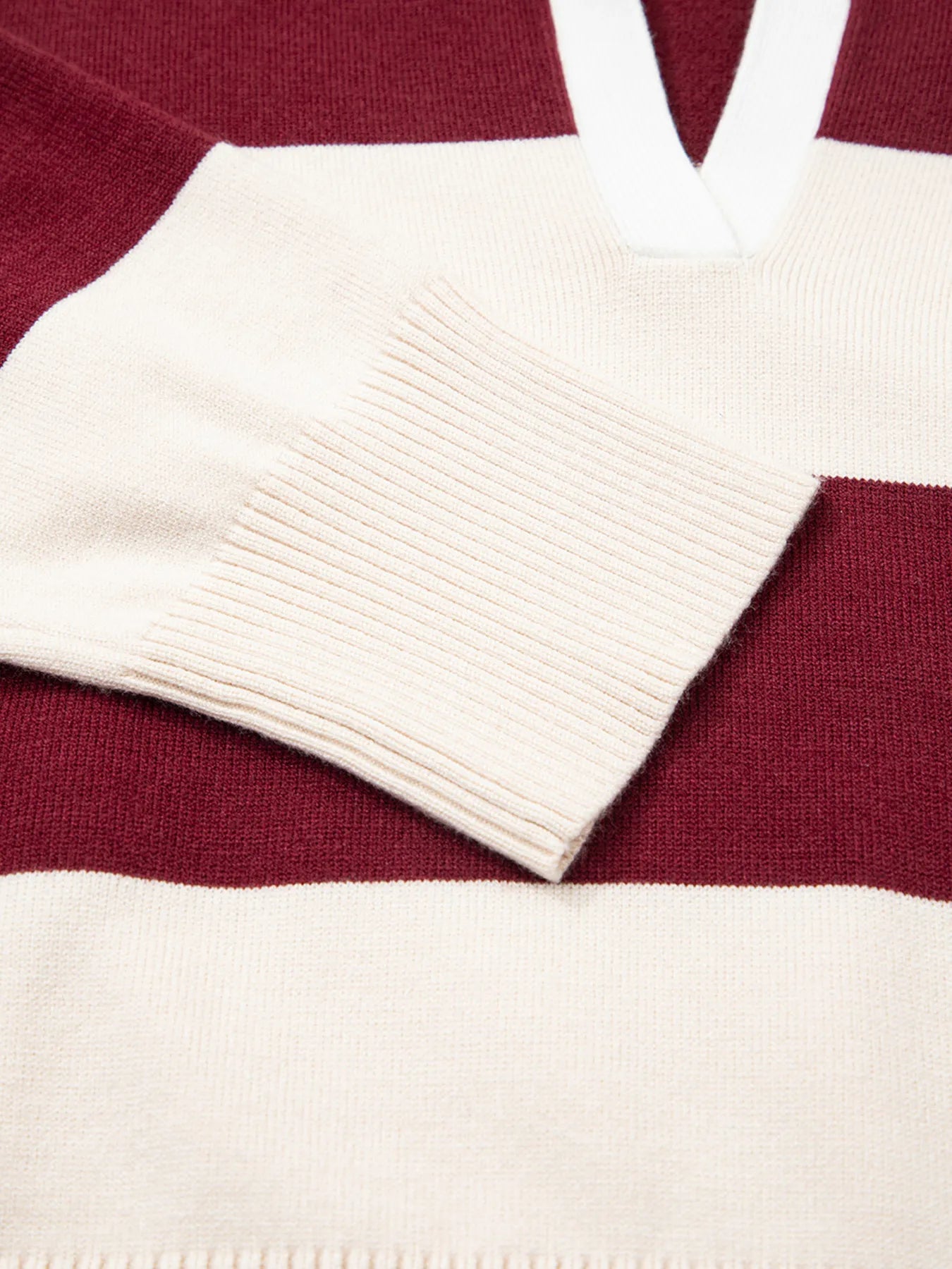 Close-up of a red and white striped sweater with a V-neck design.