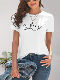Person wearing a white t-shirt with 'Smile' text and smiley face design, holding a denim jacket.