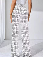 Person wearing black and white checkered pants on a light background