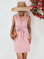 Woman wearing a pink dress and wide-brimmed hat with a floral background