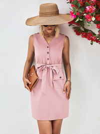 Woman wearing a pink dress and wide-brimmed hat with a floral background