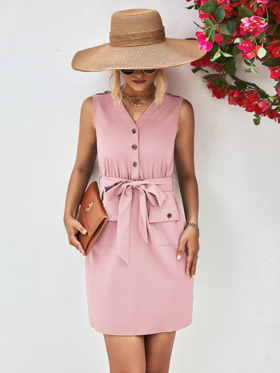 Woman wearing a pink dress and wide-brimmed hat with a floral background