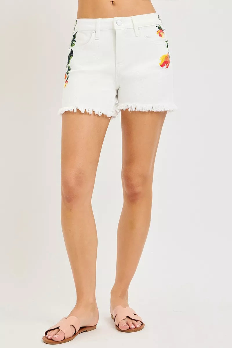 White denim shorts with floral embroidery on a white background