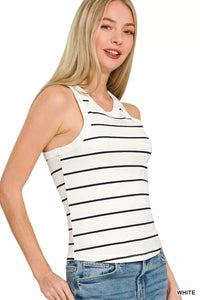 Woman wearing a white tank top with black stripes and blue jeans on a white background