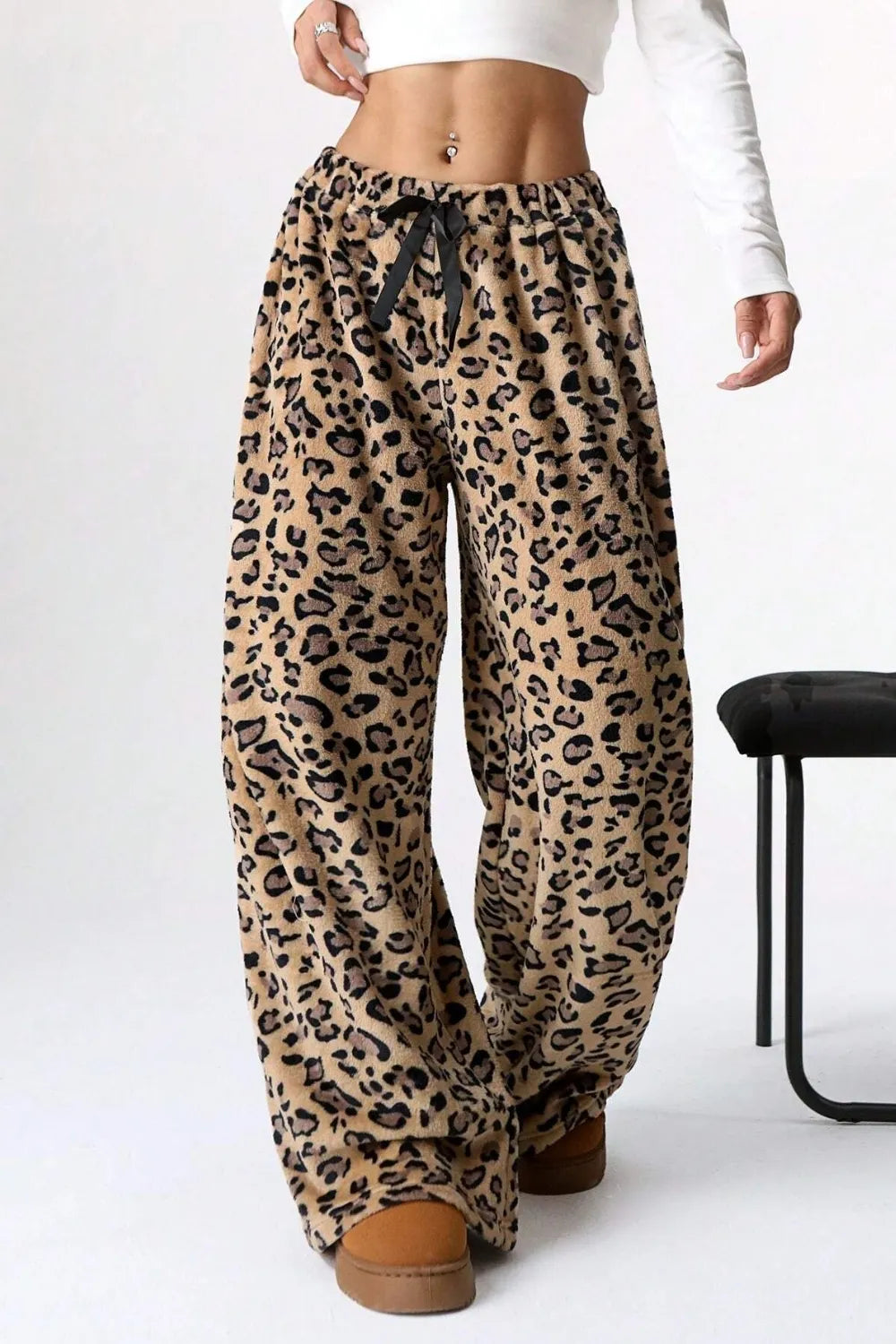 Leopard print pants worn by a person on a white background