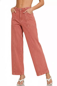 Pink jeans worn by a person on a white background