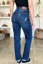 Person wearing blue jeans with a visible brand logo in an indoor setting.