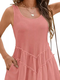 Pink sleeveless dress worn by a person on a plain background