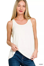 Woman wearing a white sleeveless top and blue jeans on a white background