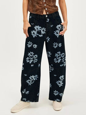 Person wearing black floral-patterned jeans on a white background