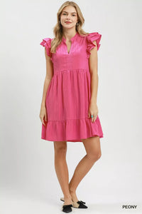 Woman wearing a pink dress with ruffled sleeves on a white background