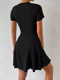 Black dress worn by a person on a light gray background