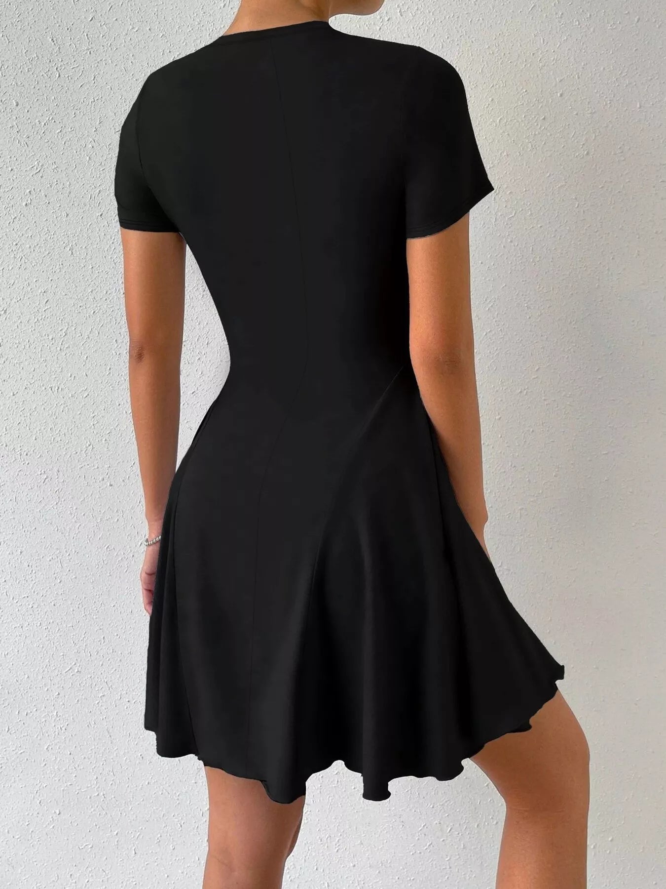 Black dress worn by a person on a light gray background