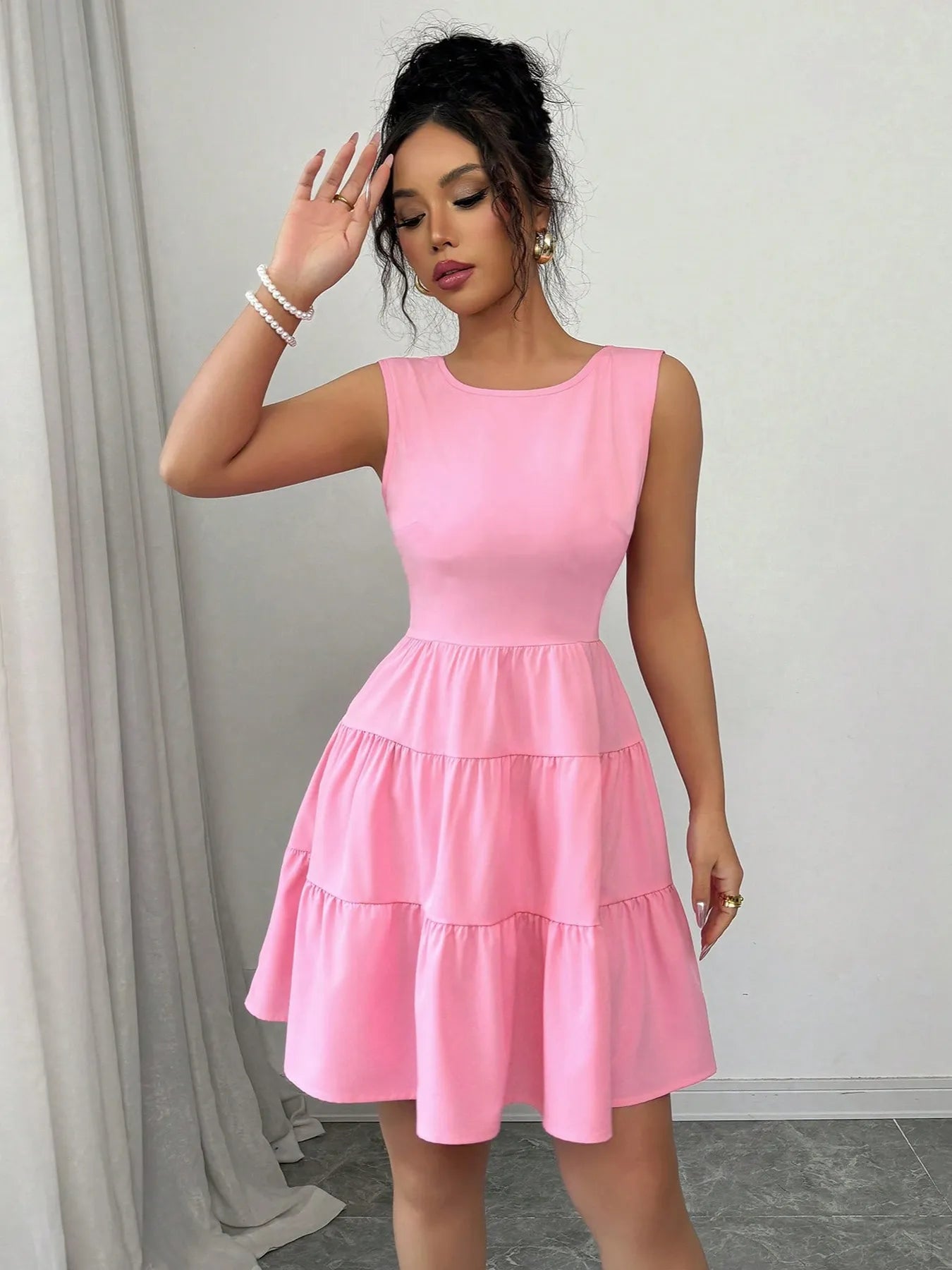 Woman wearing a pink dress against a neutral background