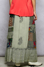 Long, patchwork skirt with intricate patterns on a neutral background