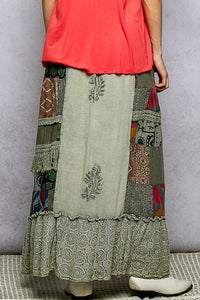 Long, patchwork skirt with intricate patterns on a neutral background