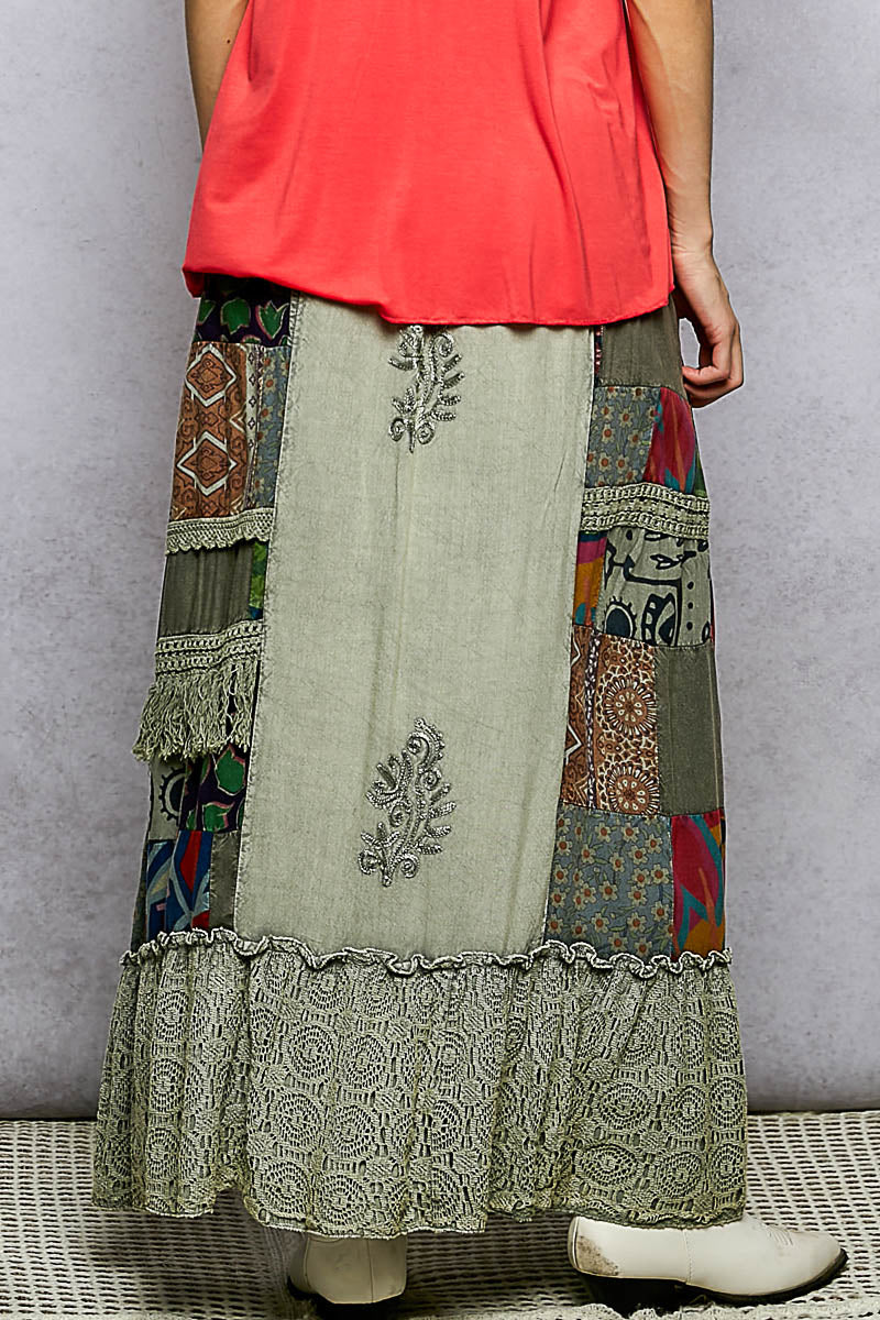 Long, patchwork skirt with intricate patterns on a neutral background