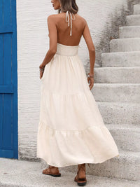 Woman in a white dress standing on a staircase with a blue door in the background