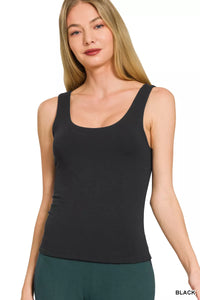 Woman wearing a black tank top on a white background