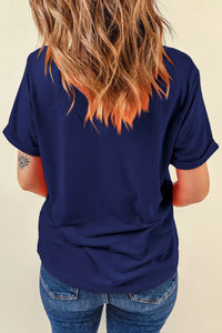Person wearing a navy blue t-shirt and blue jeans with a neutral background