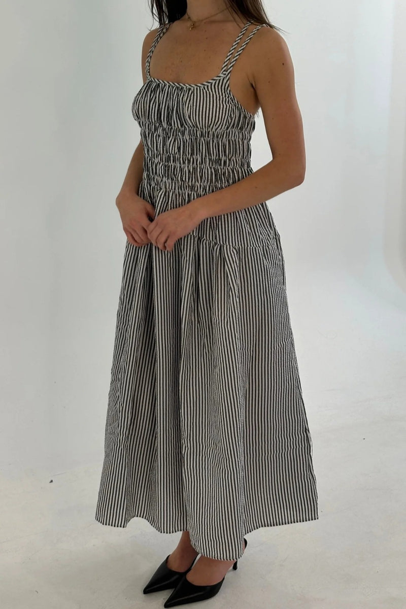 Woman wearing a black and white striped dress on a white background