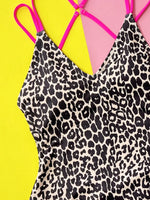 Leopard print swimsuit with pink straps on a yellow background