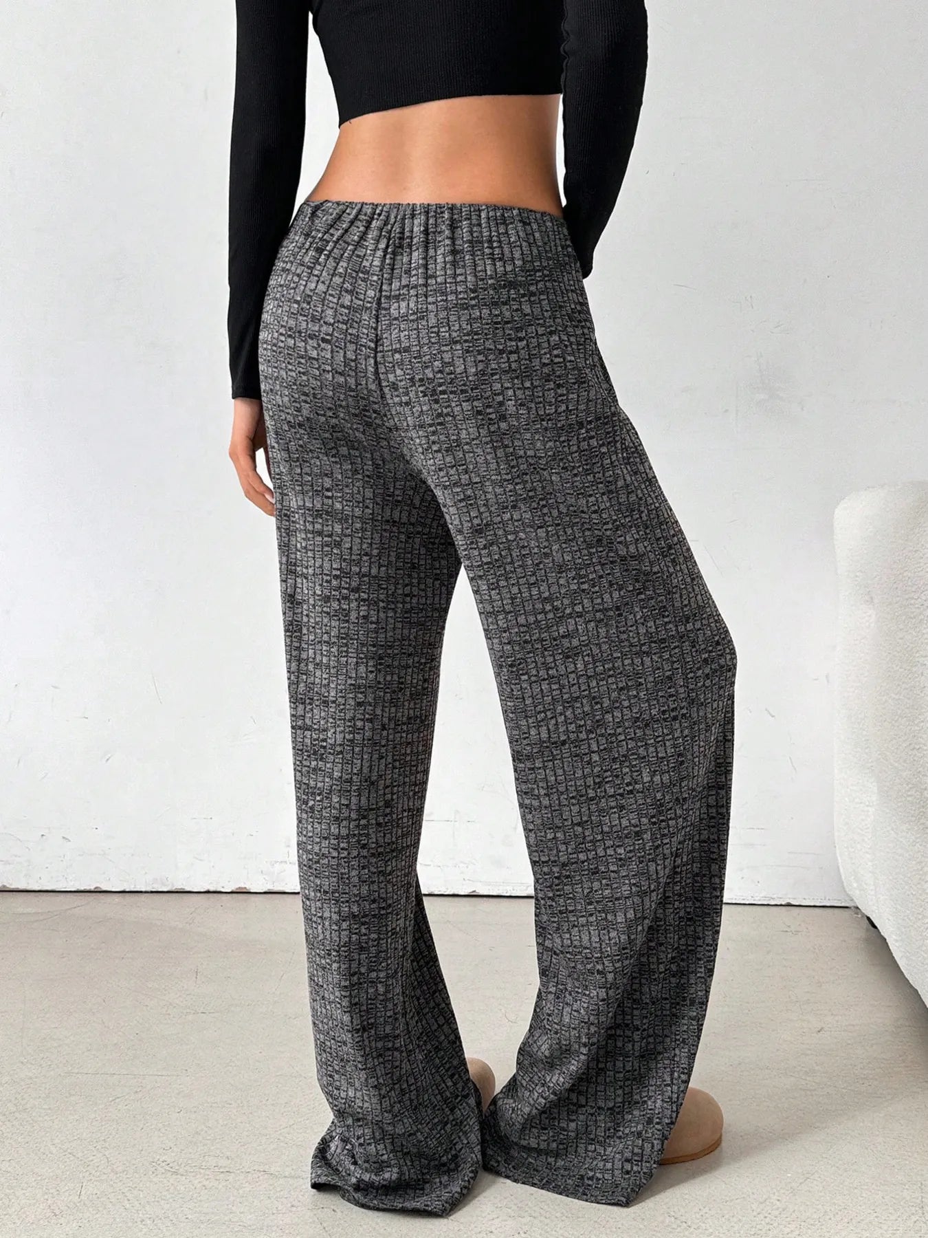 Person wearing gray checkered pants with a white background